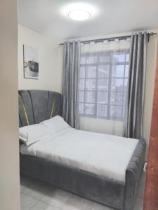a bed in a room with a window at Achievers stays in Kitengela 
