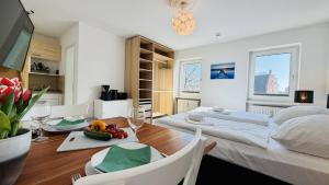 a bedroom with a bed and a dining room with a table at CBlue "Apartmenthaus Padua", zentral in Warnemünde