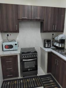 a kitchen with a stove and a microwave at Achievers stays in Kitengela 