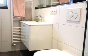 a white bathroom with a toilet and a sink at Wohnen überm Atelier in Bad Neuenahr-Ahrweiler +32 photos