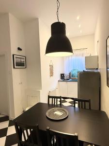 a kitchen and dining room with a black table and chairs at Willa 4 Pory Roku & Uznam in Świnoujście +127 photos