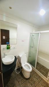 a bathroom with a shower and a toilet and a sink at Sota Residence in Pattaya South