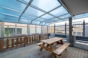 a wooden picnic table on a balcony with a view at Busan Gwangalli Nuri Hotel in Busan