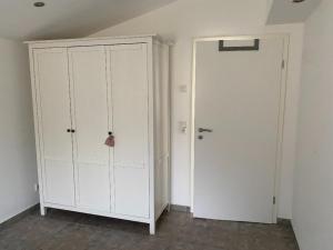 a room with a white cabinet and a door at Hyggehus in Warnitz