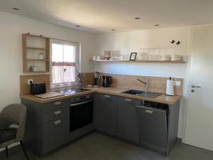 a small kitchen with a sink and a stove at Hyggehus in Warnitz