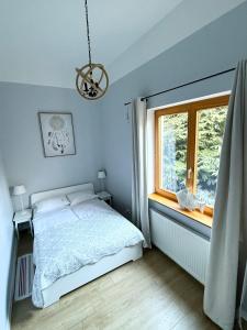 a bedroom with a bed and a window at Willa 4 Pory Roku & Uznam in Świnoujście
