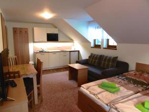 a living room with a couch and a kitchen at Pension Sima in Harrachov