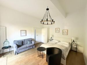 a bedroom with a bed and a couch and a chandelier at Willa 4 Pory Roku & Uznam in Świnoujście