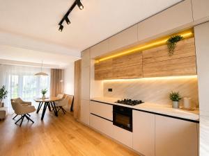 a kitchen with white cabinets and a table in a room at Da Vinci Luxury Home Otopeni in Otopeni