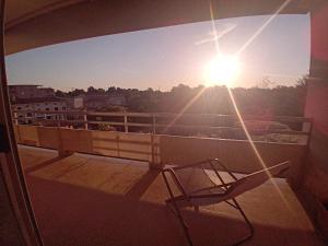 a chair on a balcony with the sun in the sky at Luna Reale Relais e Suite APARTMENTS in San Nicola La Strada