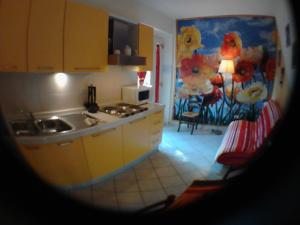 a kitchen with a sink and a kitchen with a microwave at La Casa di Ulisse B&B in Quercianella