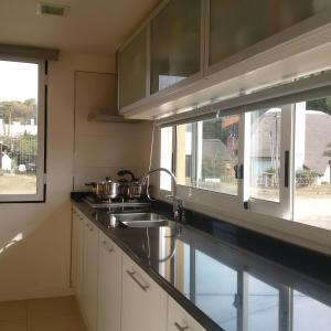 Piedra Amarilla في بونتا دل إستي: مطبخ مع حوض ونافذة