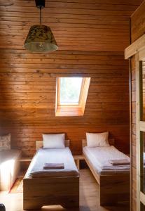 a room with two beds and a window at Rose Hip Hill Farm in Valea Tîrnei