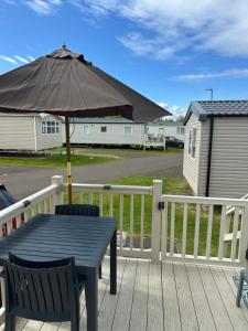 a table with an umbrella on a deck at Horizon Bay in Longniddry