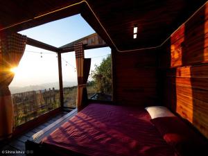 a bed in a room with a large window at Skyridge Infinity in Nuwara Eliya