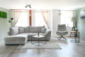 a living room with a couch and a chair at FachwerQ'sleep Apartments adults only in Quedlinburg
