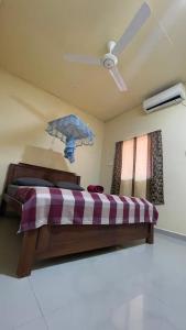 a bedroom with a bed with a ceiling fan and an umbrella at Romance in Bay in Arugam Bay