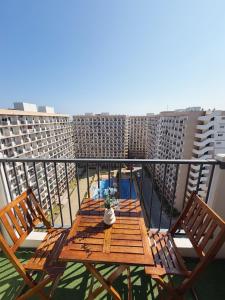 a wooden table and chairs on a balcony with buildings at The Purrfect Stay in Lapu Lapu City