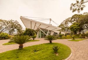 a building with a roof on top of a garden at Kawilal Hotel in Amatitlán