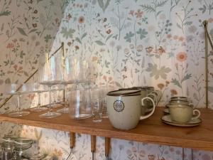 a wooden shelf with glasses and cups on it at Patak Kuckó cabin ház in Szőce