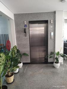 a metal elevator door in a building with potted plants at KAIBALYA Bliss in Jāmb