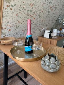 a bottle of wine on a table with two glasses at Patak Kuckó cabin ház in Szőce +32 photos