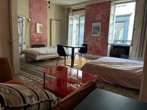a living room with a bed and a table and chairs at Chambres Zohra Centre ville in Decize