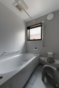 a white bathroom with a tub and a window at YOHAKU inuyama in Inuyama +12 photos