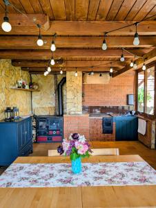 a kitchen with a vase of flowers on a table at Rose Hip Hill Farm in Valea Tîrnei +42 photos