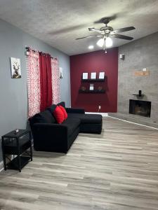 a living room with a black couch and a red wall at Sweet Spot Stone Mountain in Stone Mountain +2 photos