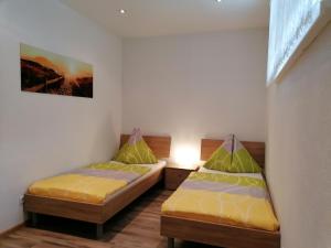 a room with two beds and a lamp in it at Gästehaus Marion Appartements in Sankt Peter ob Judenburg