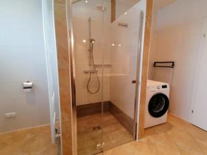 a shower with a washing machine in a bathroom at Gästehaus Marion Appartements in Sankt Peter ob Judenburg +20 photos