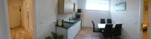 a kitchen with a sink and a table with chairs at Gästehaus Marion Appartements in Sankt Peter ob Judenburg