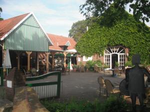 a building with a statue in front of a courtyard at Darpvenner Diele in Ostercappeln