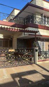a house with a fence in front of it at Cheerful homes Mysore stay in Mysore