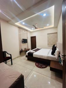 a hotel room with a bed and a tv at Maa Prabha Courtyard in Varanasi