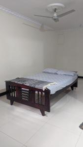 a bed in a white room with a wooden frame at Cheerful homes Mysore stay in Mysore