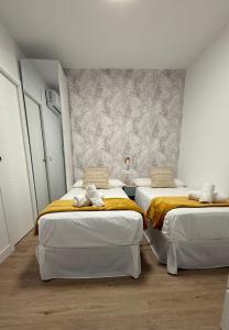 a room with two beds and a wall at Azahar Home Sevilla in Seville +5 photos