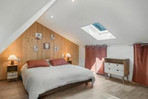 a bedroom with a large bed and a skylight at Ferme du Bien Hêtre Gîte Sérénité in Saint-Arnoult