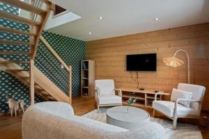 a living room with two chairs and a tv at Ferme du Bien Hêtre Gîte Sérénité in Saint-Arnoult