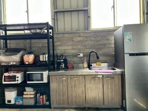 a kitchen with a sink and a refrigerator at 日沐澄旅 l 家人聚會 l 烤肉 l 戲水池 l 電動麻將 l KTV l 影音TV in Ch'ih-k'an