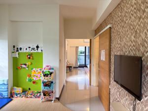 a childs room with a green wall and a tv at 日沐澄旅 l 家人聚會 l 烤肉 l 戲水池 l 電動麻將 l KTV l 影音TV in Ch'ih-k'an