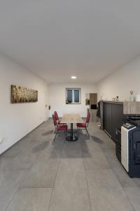 a room with a table and chairs and a kitchen at ALS Zimmer & Suiten in Lambach