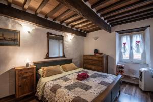 a bedroom with a bed and a dresser and windows at Andrea's Nido in Castel del Piano