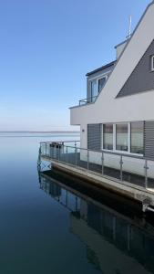 a house on a dock next to a body of water at Floating-Haus Meerferien in Bitterfeld