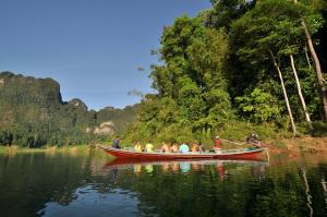a group of people in a boat on the water at Coco Khao Sok Hostel in Khao Sok National Park
