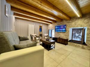 a living room with a couch and a tv at La Casa sull'Arco in Pacentro
