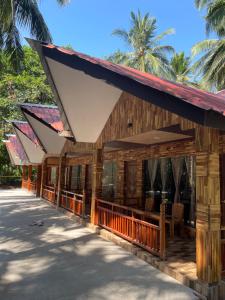 a building with awnings on it with palm trees in the background at Jungle Beach Resort in Neil Island