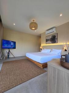 a bedroom with a large bed and a flat screen tv at Kiree River Hotel โรงแรมคิรีริเวอร์ in Ban Thong Pha Phum