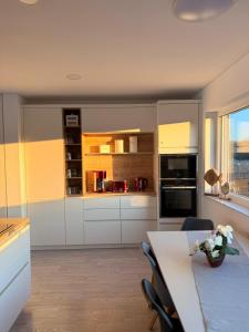 a kitchen with white cabinets and a table with flowers on it at Floating-Haus Meerferien in Bitterfeld